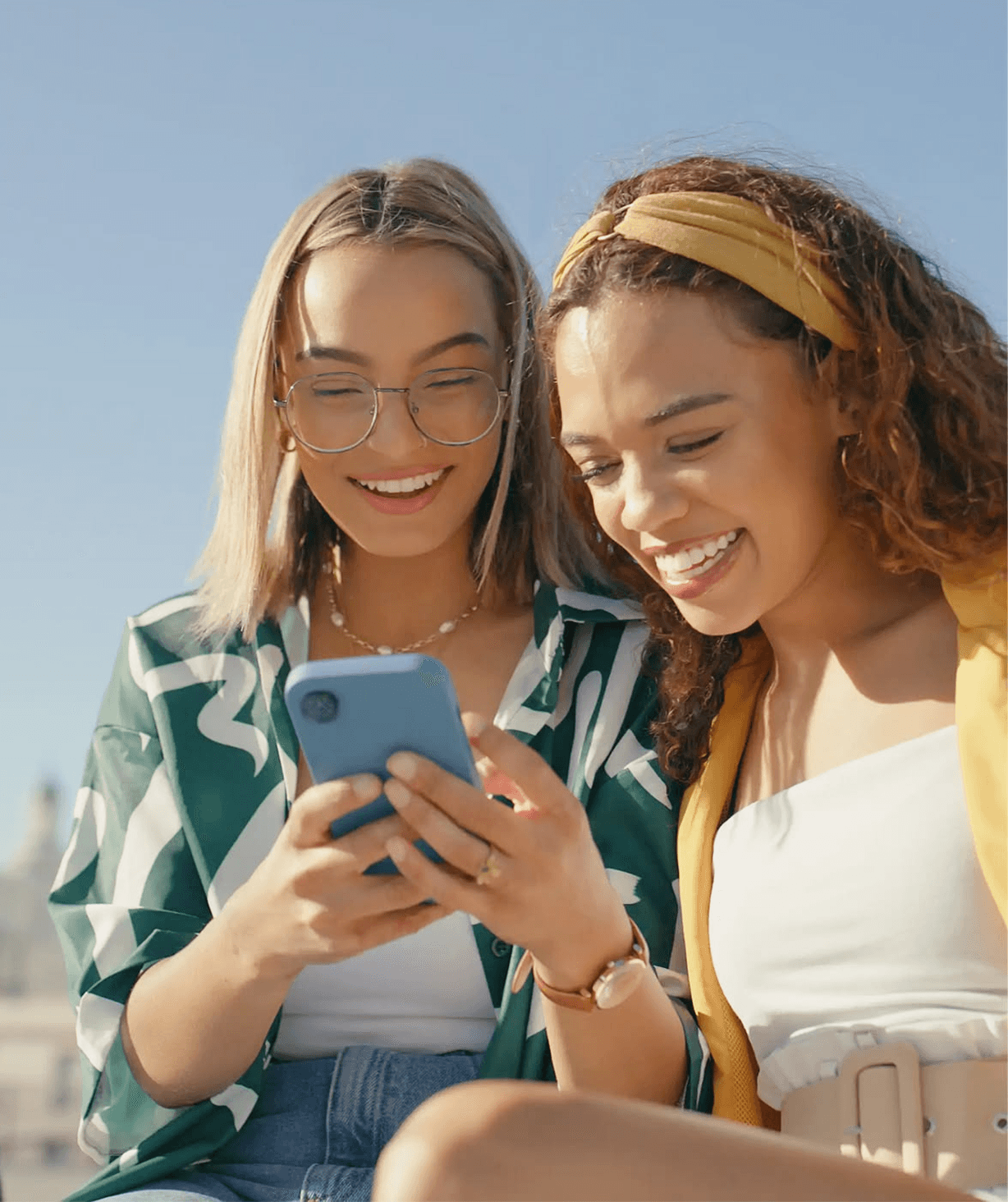 Two women smiling at a phone together